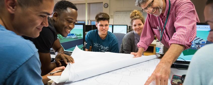 在乔治城校园，建筑工程专业的学生和他们的老师一起看蓝图.